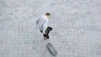 俯视的年轻人一条腿拄着拐杖在滑板上旋转，做着花样。 残疾人培训